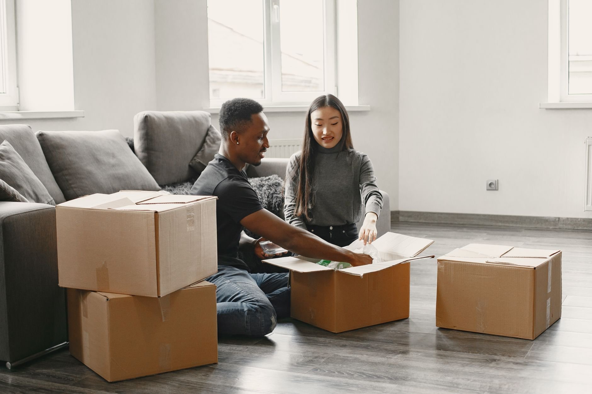 A happy couple unpacking boxes in their new apartment, settling into a new home.